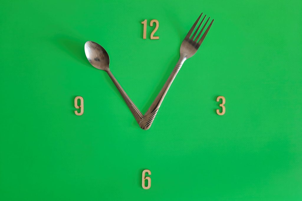 Fork and spoon mimic clock hands for intermittent fasting schedule