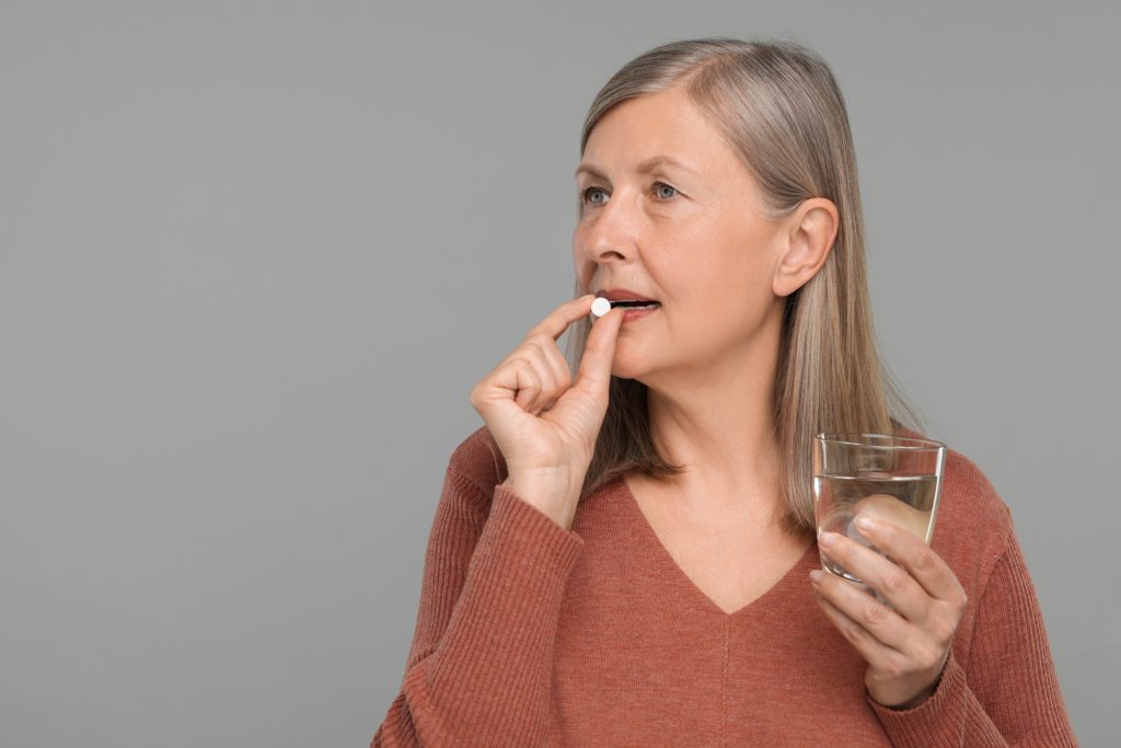 Middle age woman taking supplement for mineral deficiency