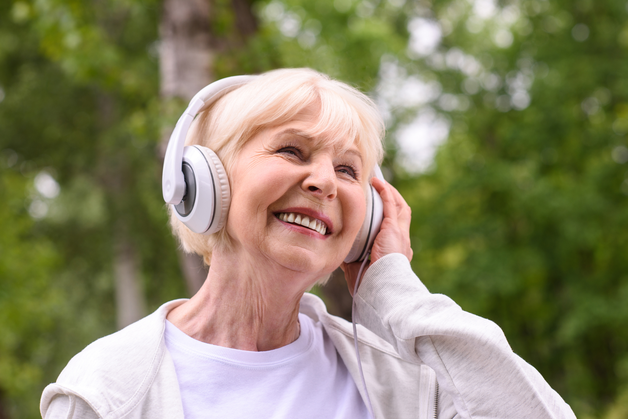 Senior woman smiling while listening to music.