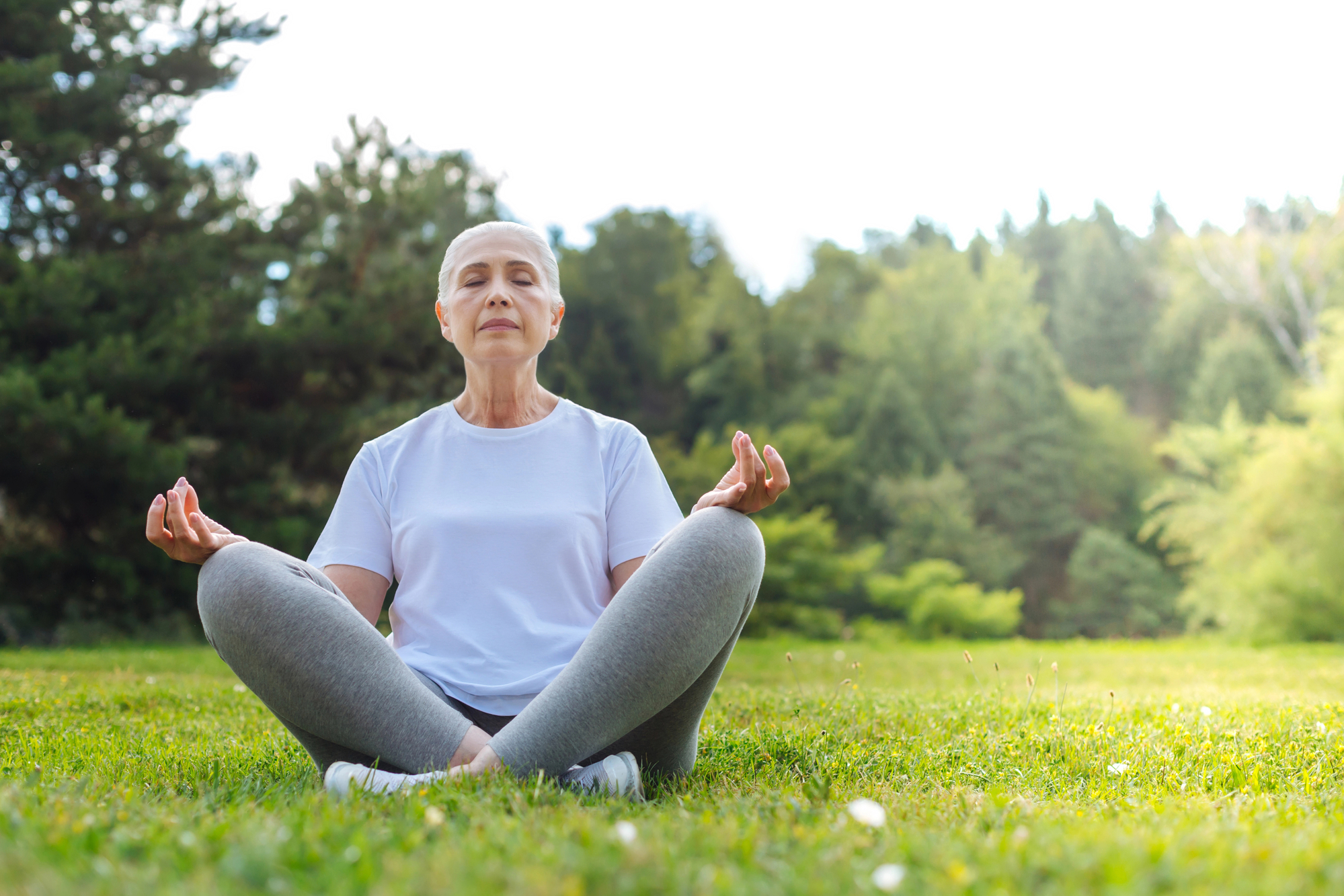 Senior woman doing gratitude practices for women like meditating.