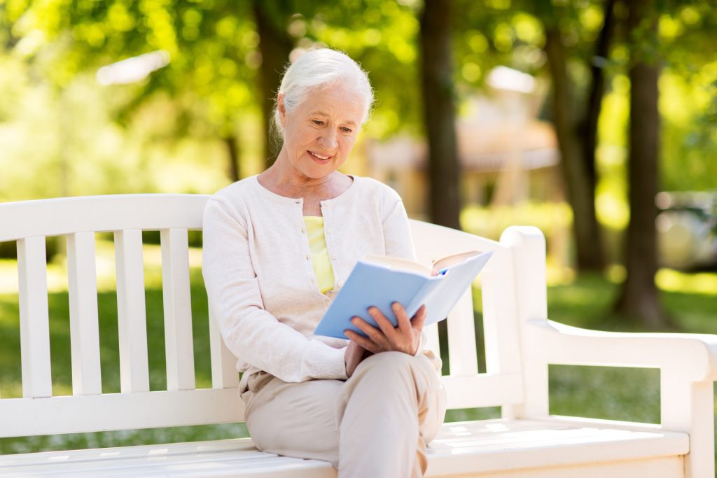 Woman reading peacefully to avoid stress.