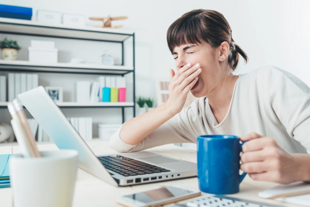 Woman yawning while working.