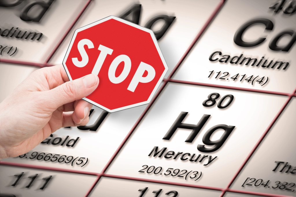 Stop sign over periodic table highlighting mercury element.