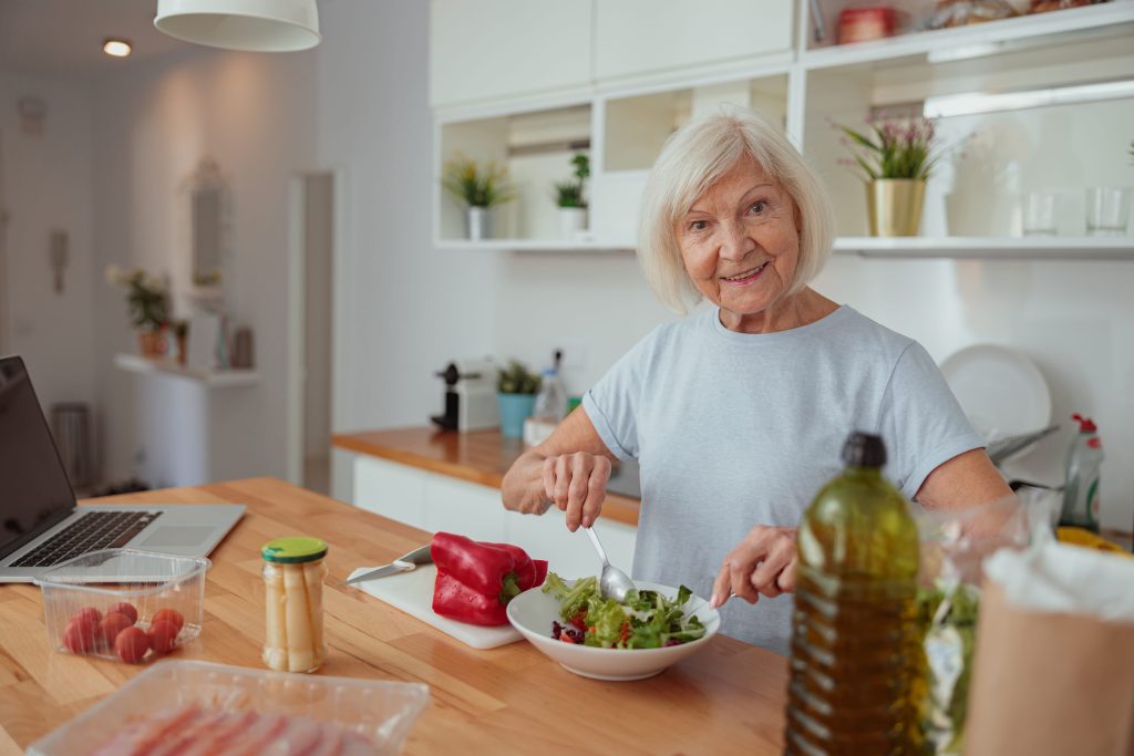 Senior woman eating healthy food to support her gut regeneration.