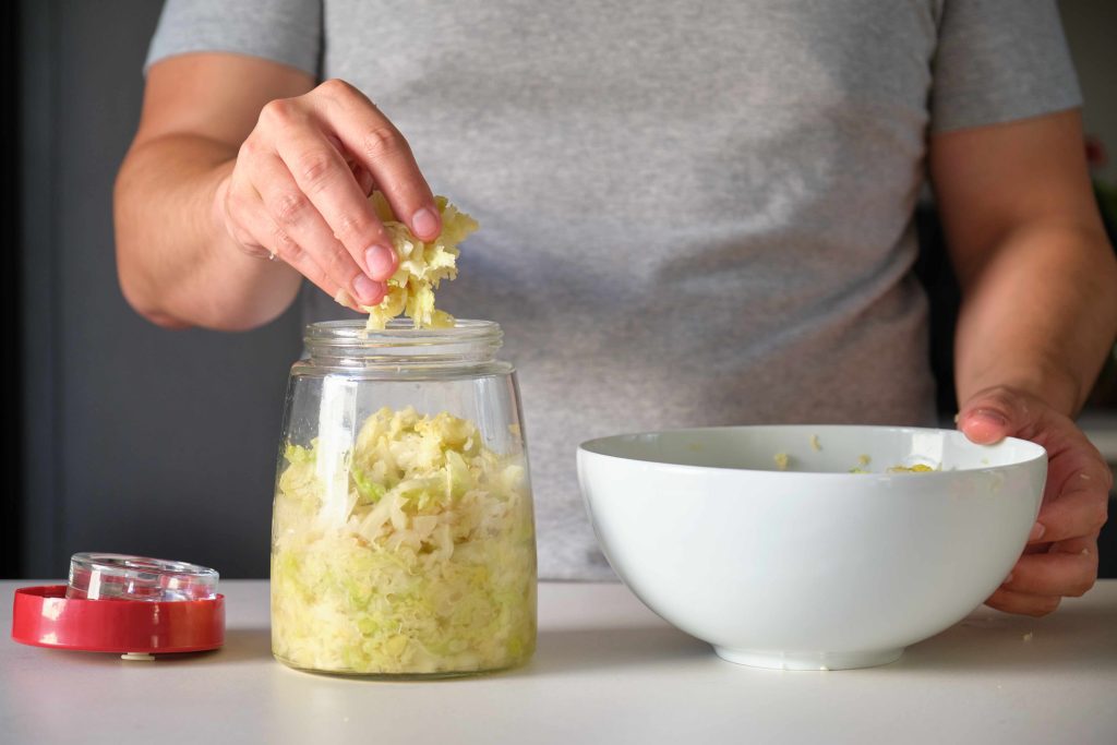 Woman making sauerkraut at home.