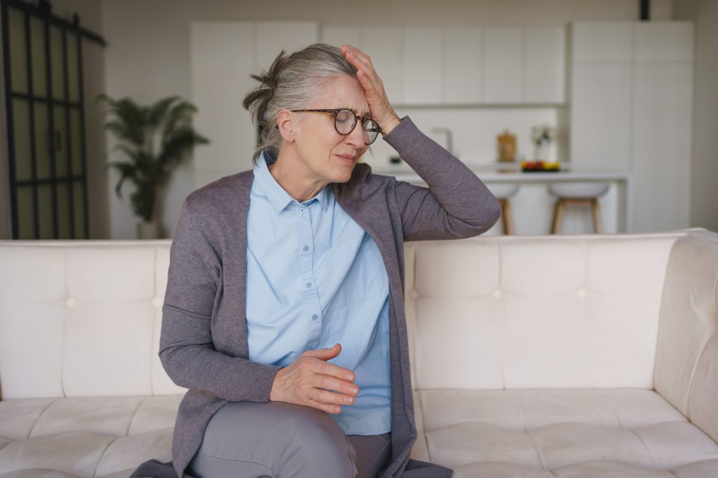Mature woman on sofa suffering from stress