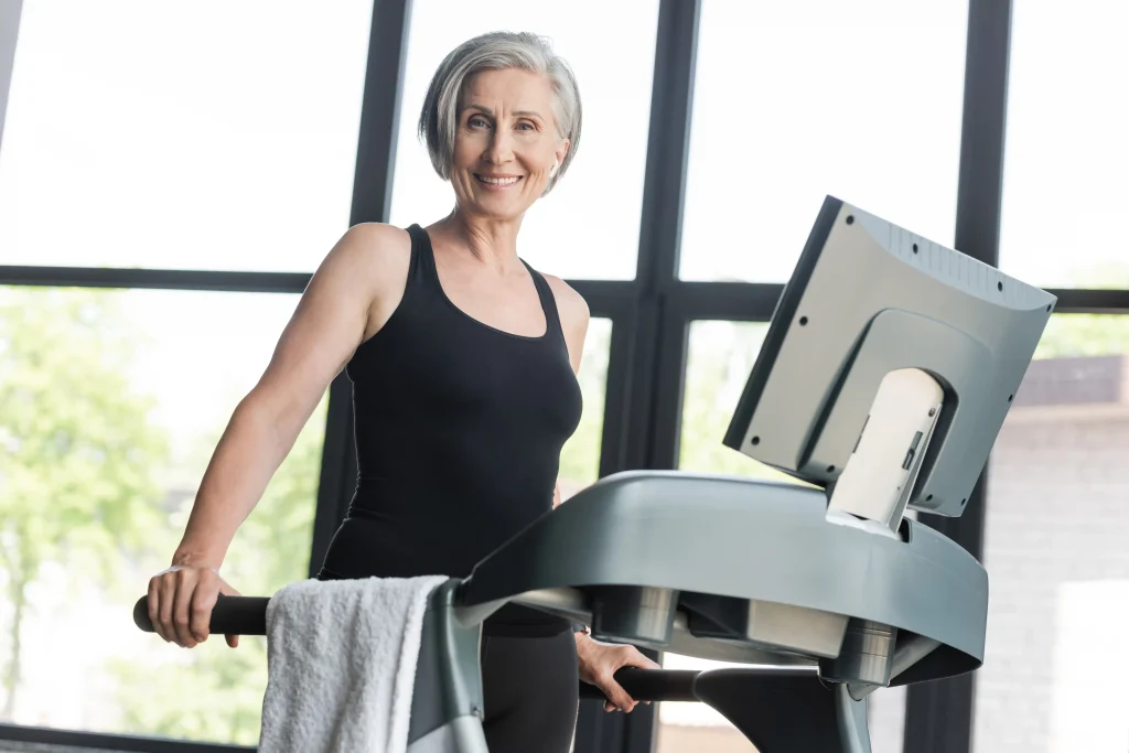Grey-haired woman smiling outdoors, at the easy conversational pace that adds up across a day